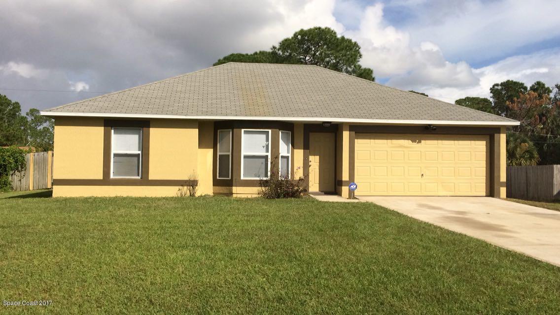 161 Tucson Road Southwest Palm Bay, FL 32908 - Photo 1 of 31 a front view of a house with a garden and yard