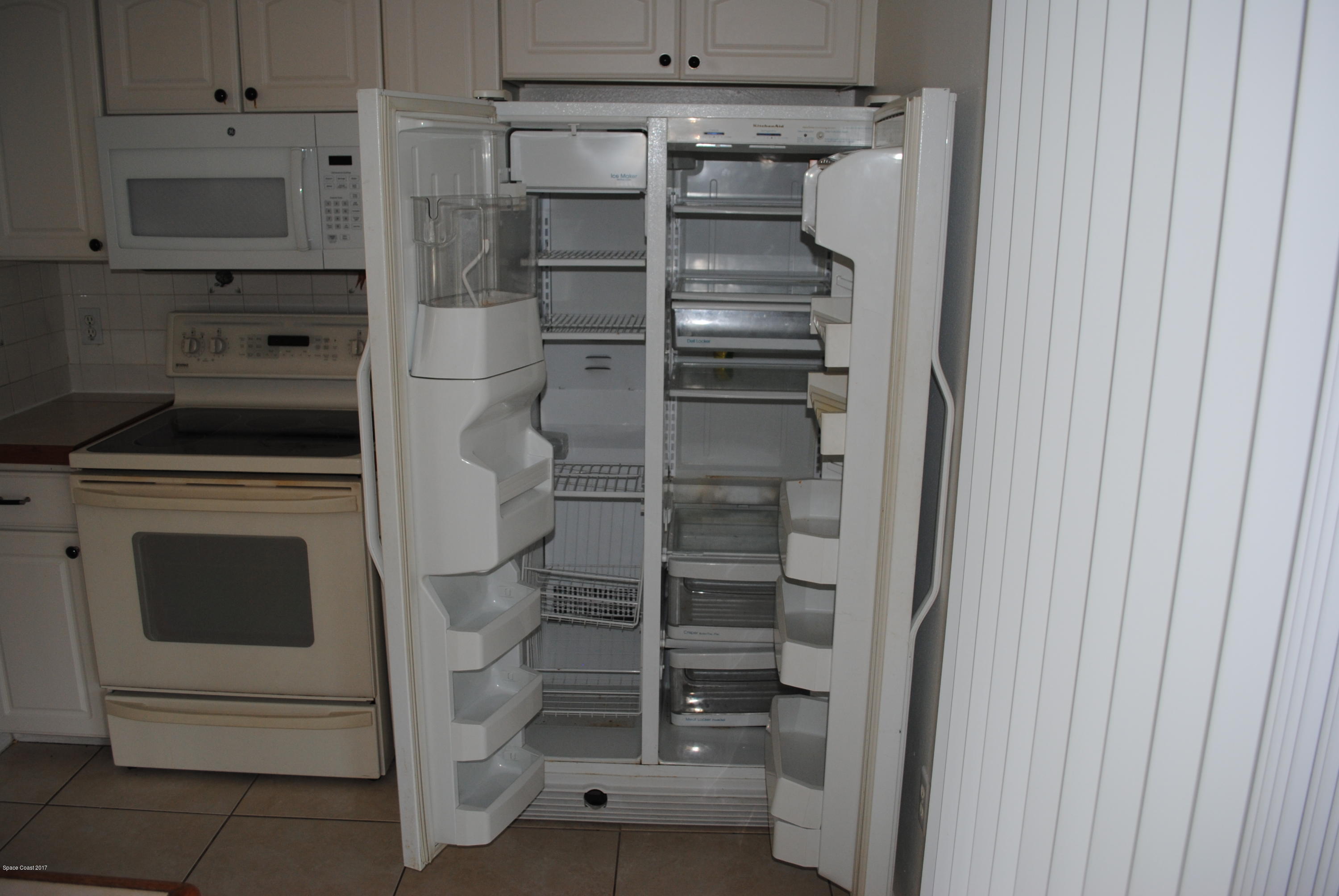161 Tucson Road Southwest Palm Bay, FL 32908 - Photo 18 of 31 a kitchen with a refrigerator and cabinets