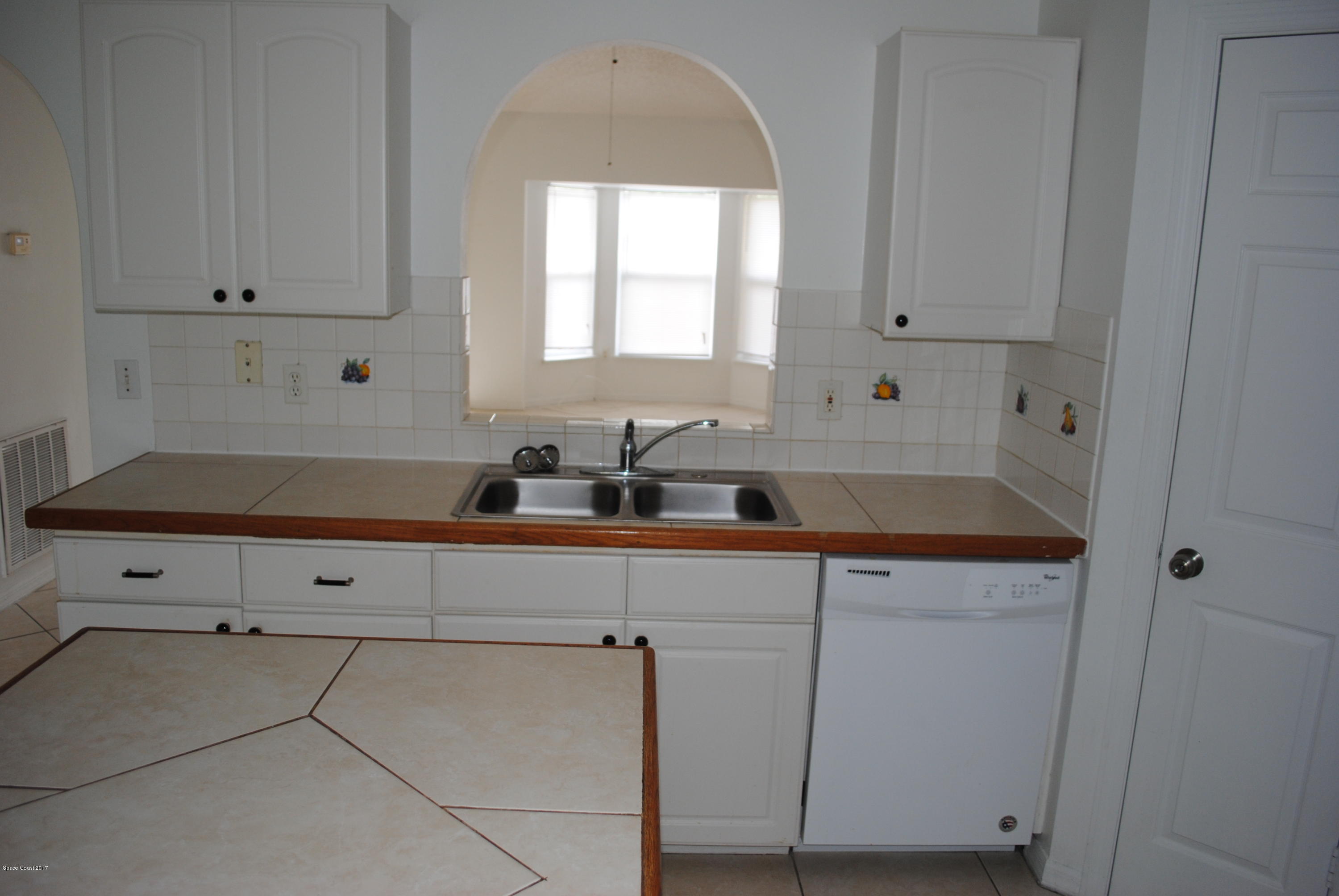161 Tucson Road Southwest Palm Bay, FL 32908 - Photo 19 of 31 a kitchen with white cabinets and a sink