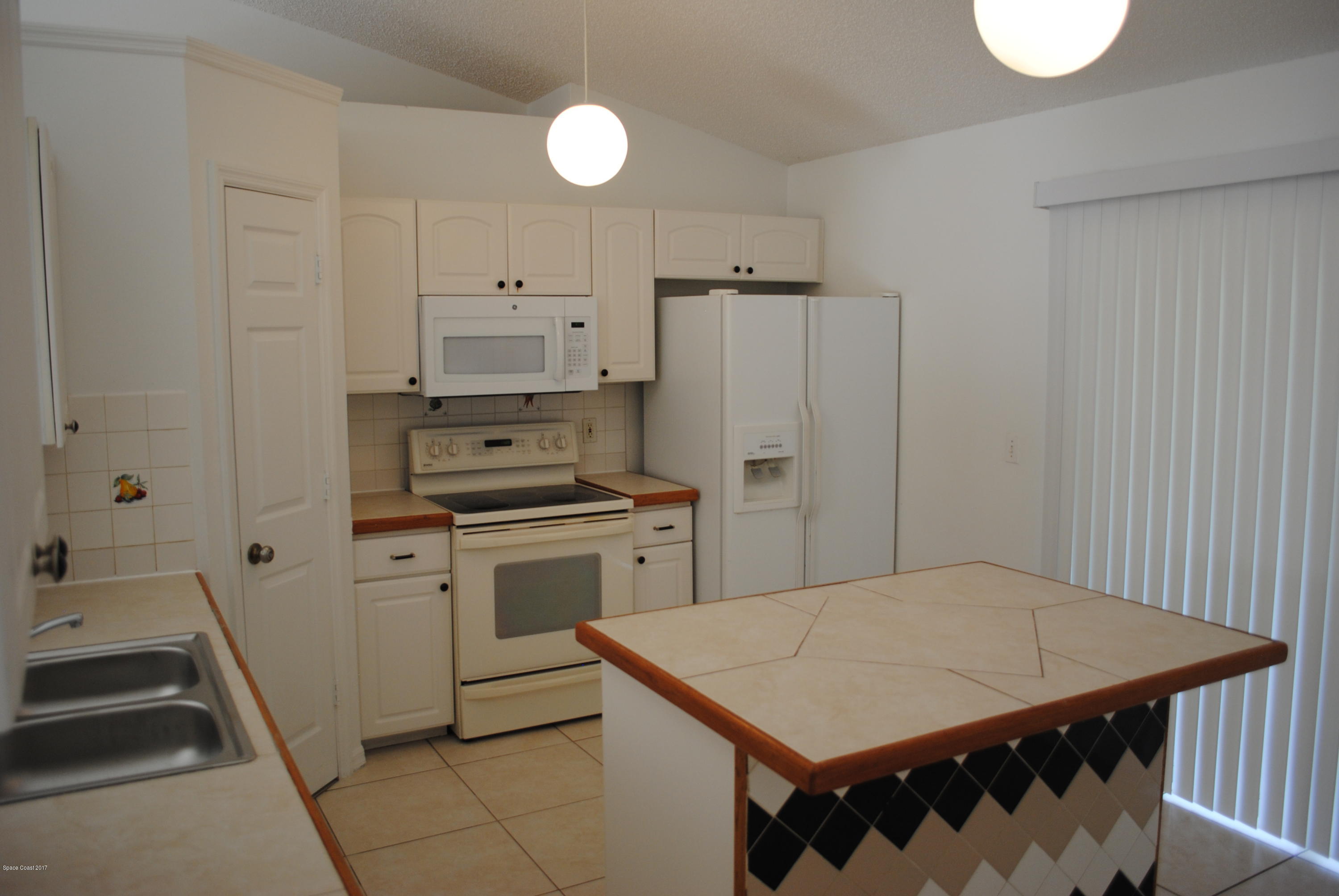 161 Tucson Road Southwest Palm Bay, FL 32908 - Photo 20 of 31 a kitchen with a stove a sink and a refrigerator