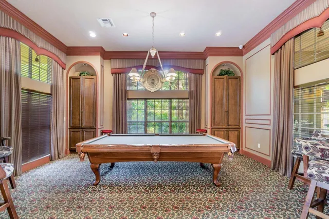 a room with pool table and windows