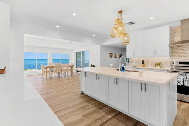 a kitchen with a sink and white cabinets with wooden floor