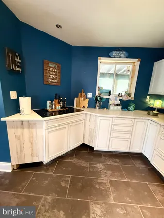 a kitchen with white cabinets and window