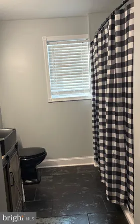 an empty room with windows and ceiling fan