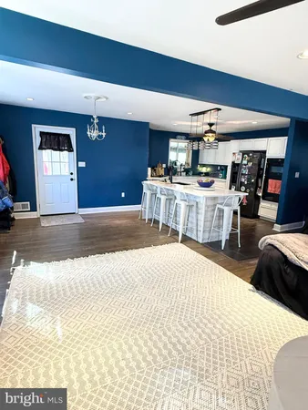 a living room with a couch and a dining table with wooden floor