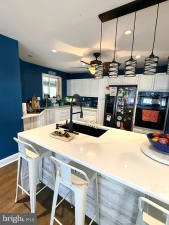 a kitchen with stainless steel appliances kitchen island a stove a sink and a refrigerator