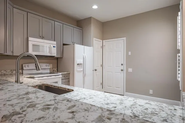 a kitchen with stainless steel appliances granite countertop a refrigerator and a stove top oven