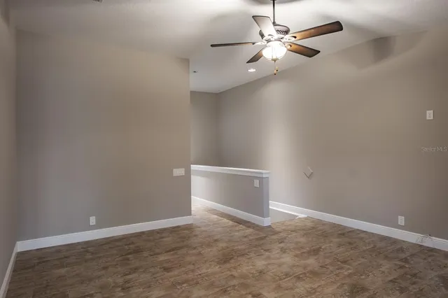 an empty room and chandelier fan