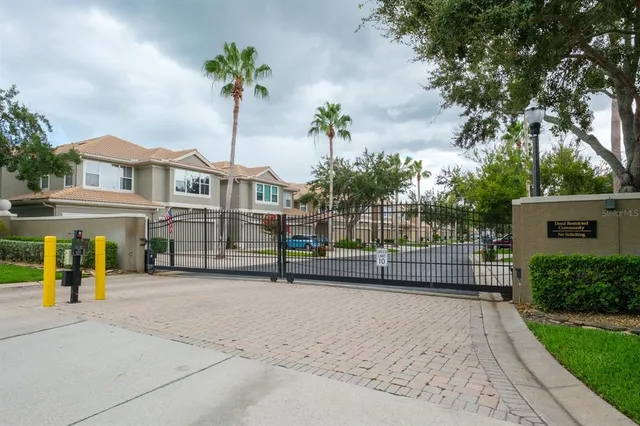 a sign that is sitting in front of a house with potted plants