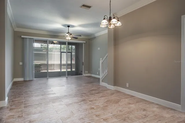 en empty room with windows and chandelier