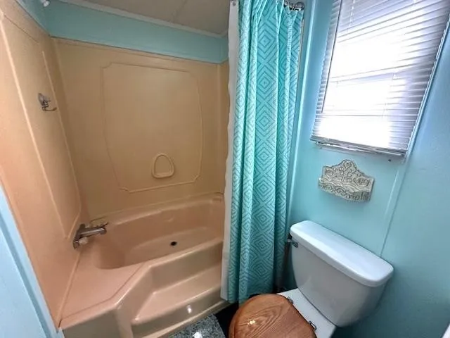 a bathroom with a toilet and a shower