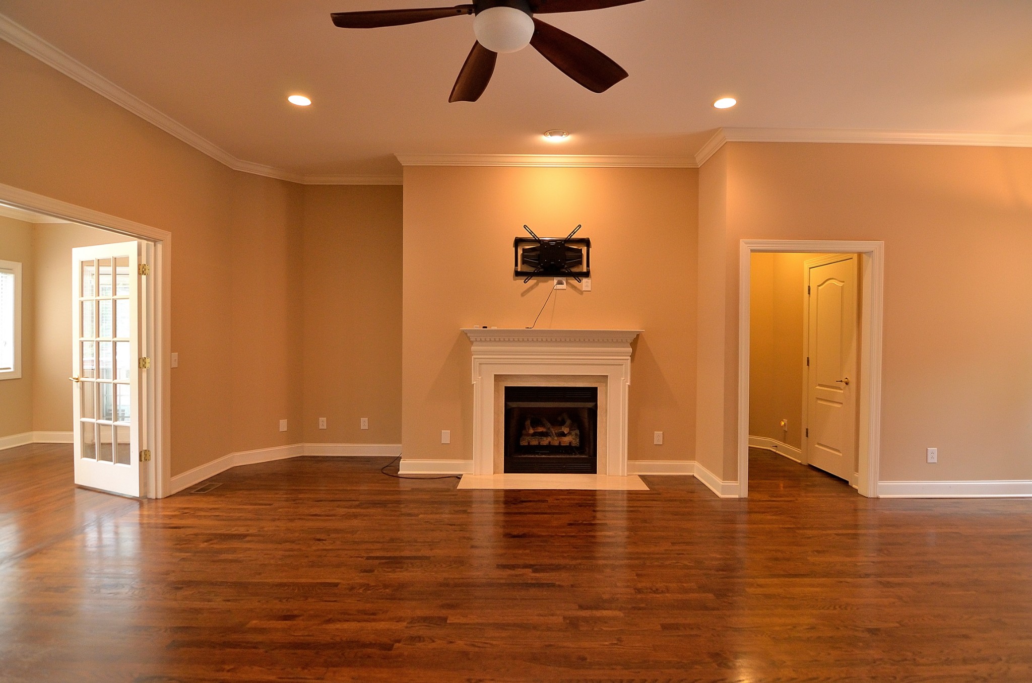 2600 Derby Run Road Springfield, TN 37172 - Photo 11 of 57 an empty room with wooden floor a fireplace a ceiling fan and kitchen view