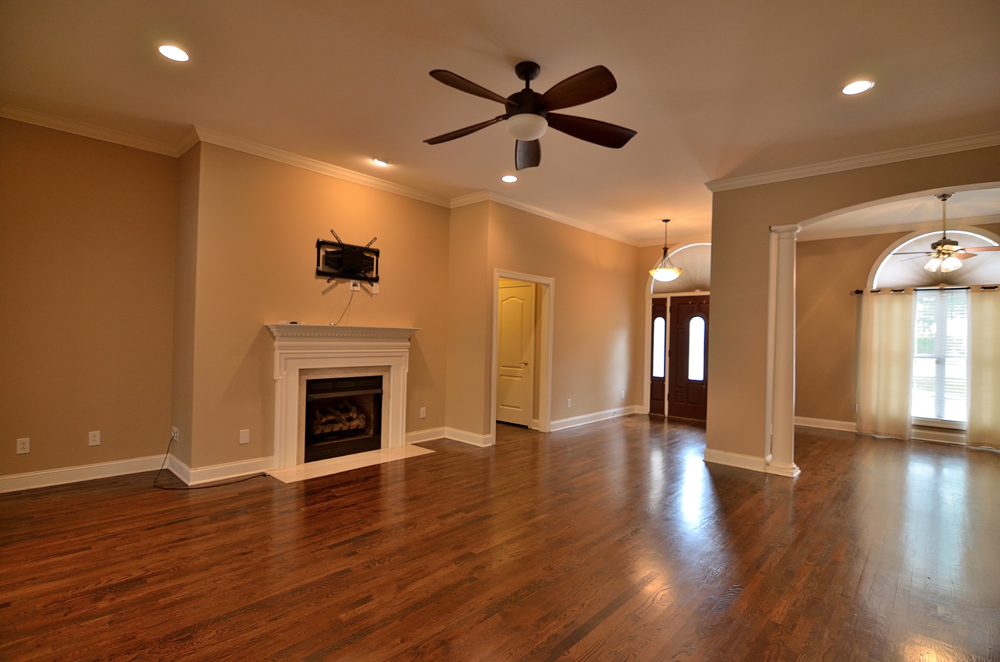 2600 Derby Run Road Springfield, TN 37172 - Photo 10 of 57 an empty room with wooden floor a ceiling fan a fireplace and windows