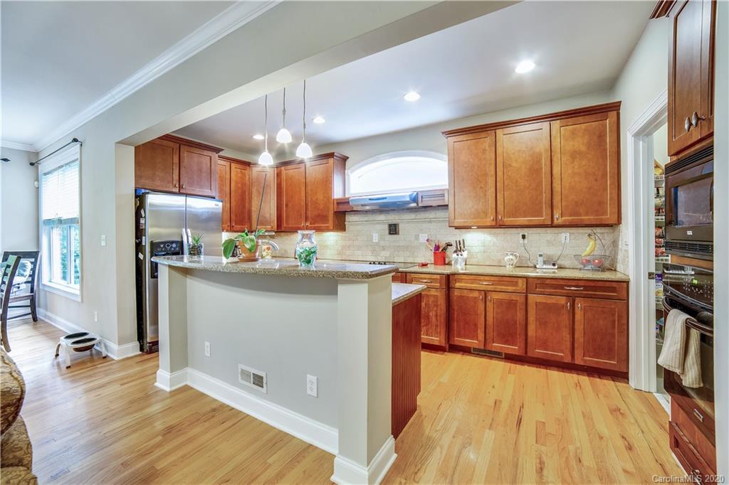 1346 Crown Ridge Drive Fort Mill, SC 29708 - Photo 3 of 36 a kitchen with stainless steel appliances granite countertop a refrigerator a sink dishwasher a stove with wooden cabinets and floor