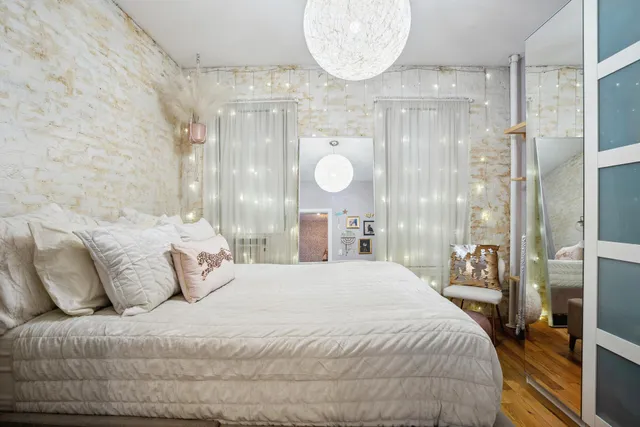 a bedroom with a large bed and a chandelier