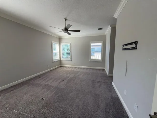 a view of empty room with windows and ceiling fan