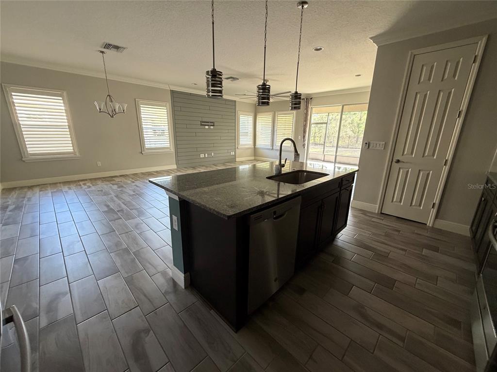 6204 Colmar Place Apollo Beach, FL 33572 - Photo 35 of 57 a kitchen with stainless steel appliances granite countertop a sink a counter space and wooden floor