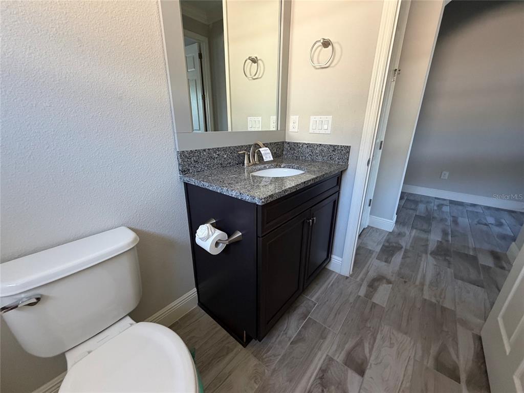 6204 Colmar Place Apollo Beach, FL 33572 - Photo 42 of 57 a bathroom with a granite countertop toilet sink and mirror