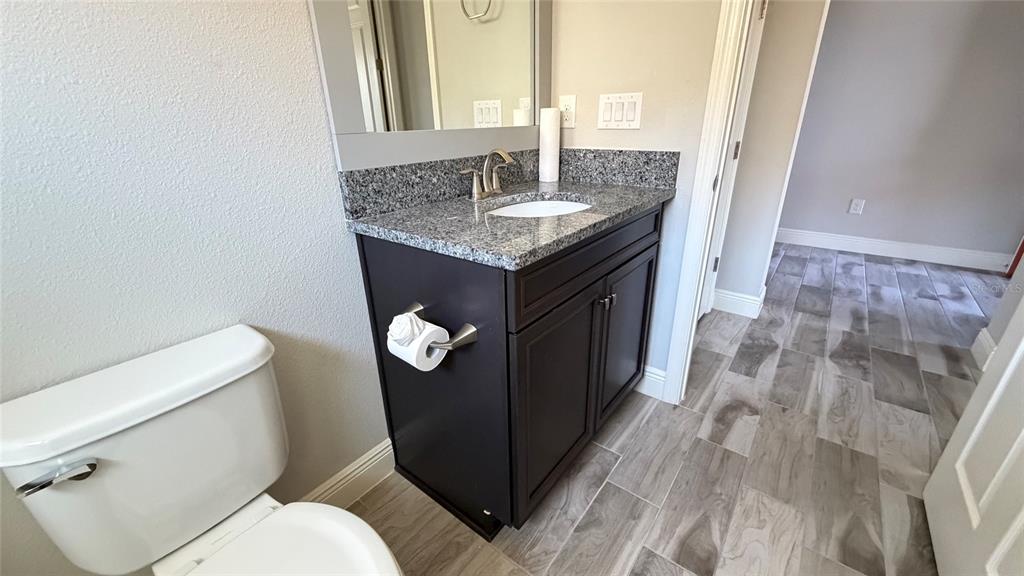6204 Colmar Place Apollo Beach, FL 33572 - Photo 52 of 57 a bathroom with a granite countertop toilet sink and mirror