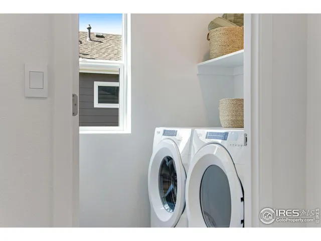 a view of washer and dryer with bathroom in the background