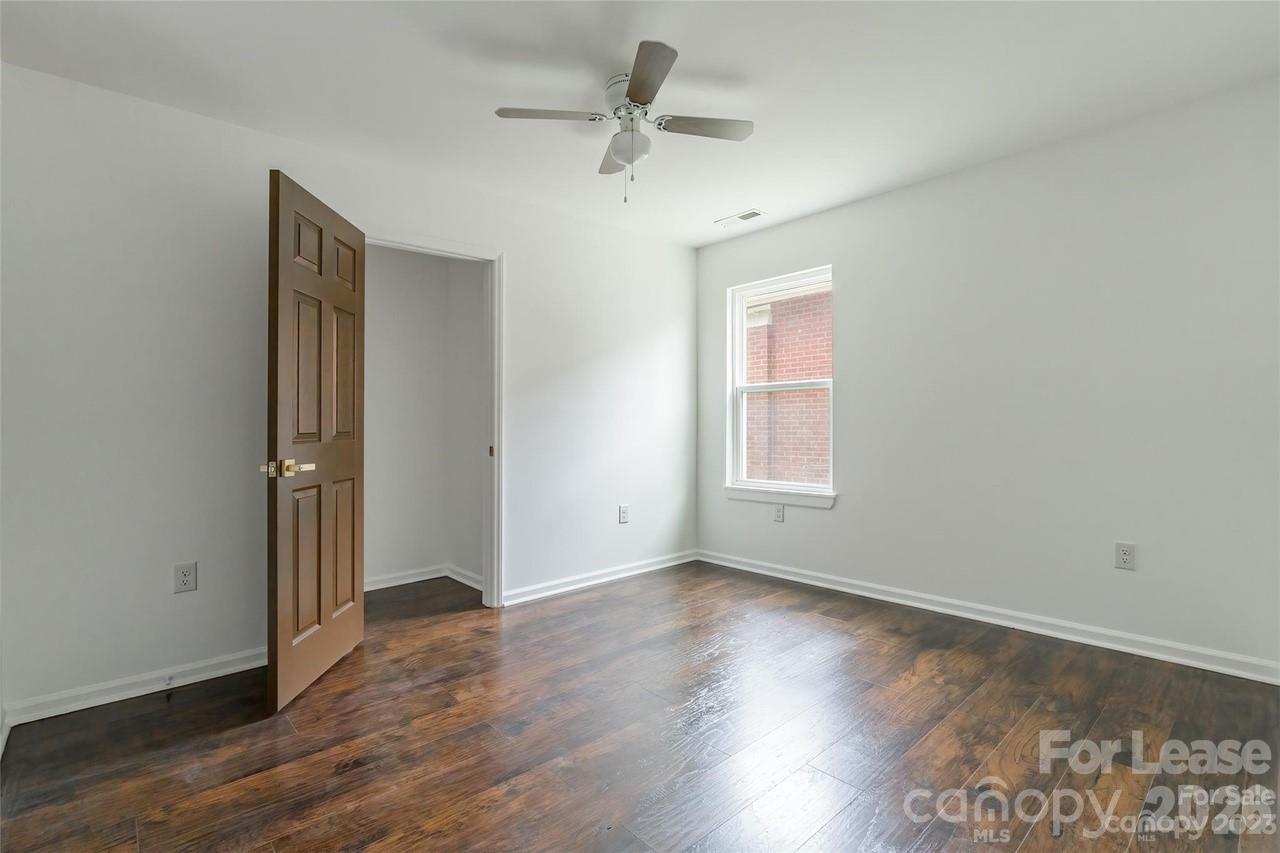 303 Cabarrus Avenue West Concord, NC 28025 - Photo 13 of 17 an empty room with wooden floor chandelier fan and windows