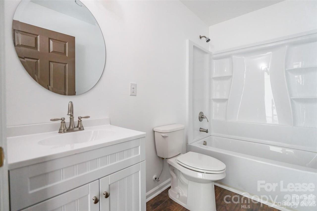 303 Cabarrus Avenue West Concord, NC 28025 - Photo 17 of 17 a bathroom with a toilet a sink and a mirror