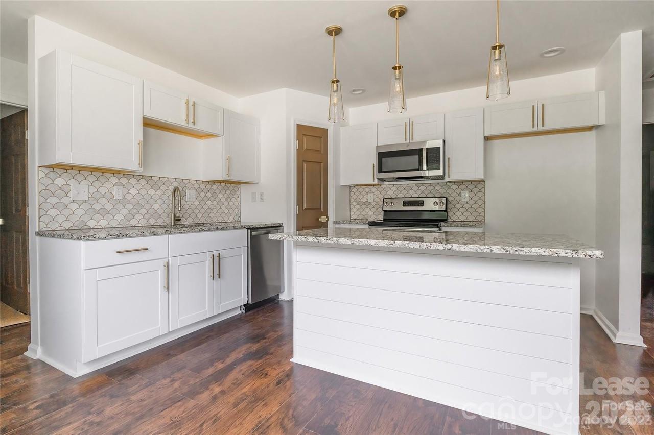 303 Cabarrus Avenue West Concord, NC 28025 - Photo 5 of 17 a kitchen with stainless steel appliances granite countertop a stove a sink and a refrigerator