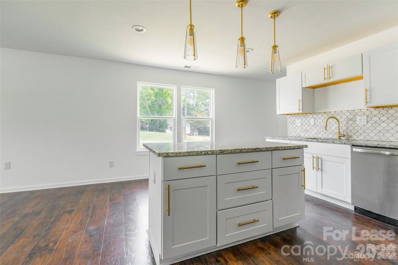 303 Cabarrus Avenue West Concord, NC 28025 - Photo 8 of 17 a kitchen with granite countertop white cabinets and white appliances