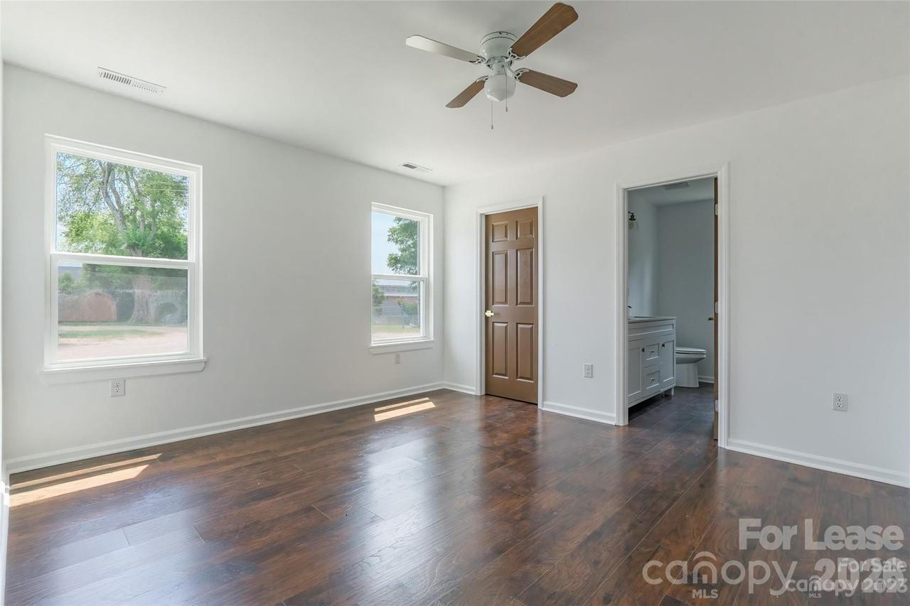 303 Cabarrus Avenue West Concord, NC 28025 - Photo 9 of 17 a view of an empty room with a window and wooden floor