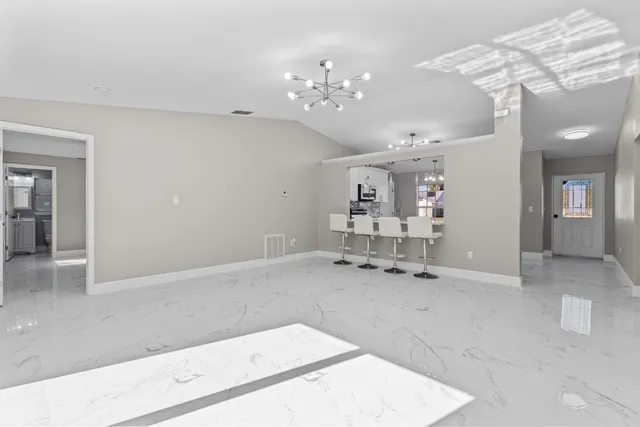 a view of a hallway with dining area and chandelier