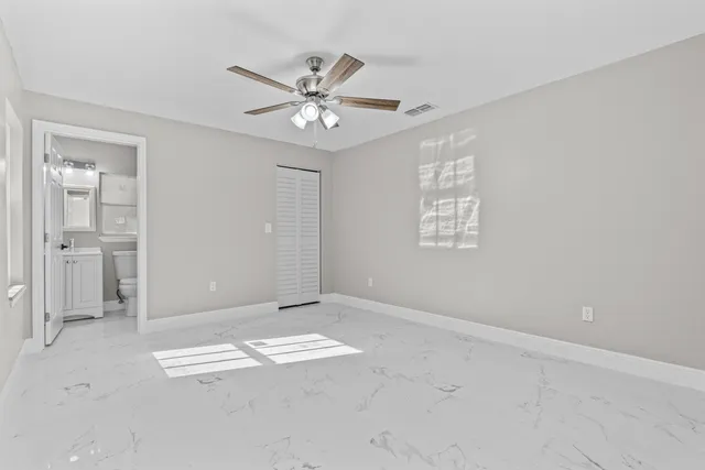 an empty room with closet and windows