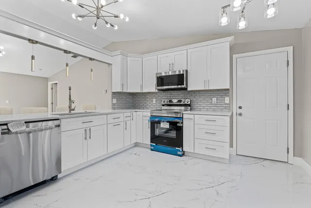 a kitchen with stainless steel appliances a refrigerator sink and cabinets