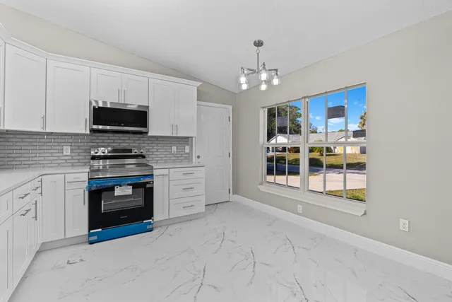 a kitchen with stainless steel appliances granite countertop a stove and a refrigerator