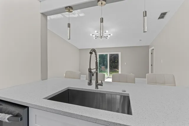 a kitchen with a sink and chandelier