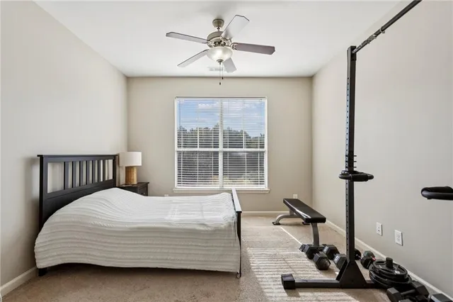 a bedroom with a bed a window and potted plant