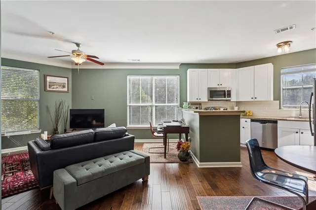 a living room with furniture a fireplace and a dining table with wooden floor