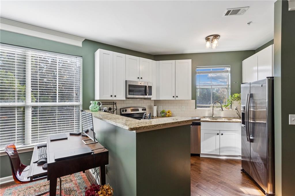 10 Perimeter Summit Boulevard, Unit 4337 Atlanta, GA 30319 - Photo 8 of 21 a kitchen with stainless steel appliances a stove top oven a sink dishwasher and a refrigerator