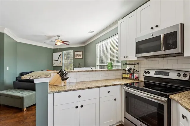 a kitchen with granite countertop a sink dishwasher stove and oven with wooden floor