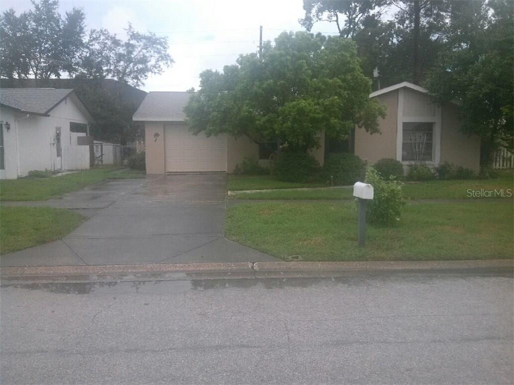 11721 Nature Trail Port Richey, FL 34668 - Photo 1 of 1 a view of a house with a yard and a garage