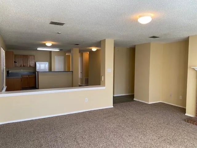 a view of a kitchen with a refrigerator and a sink