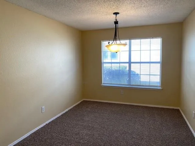 an empty room with windows and chandelier
