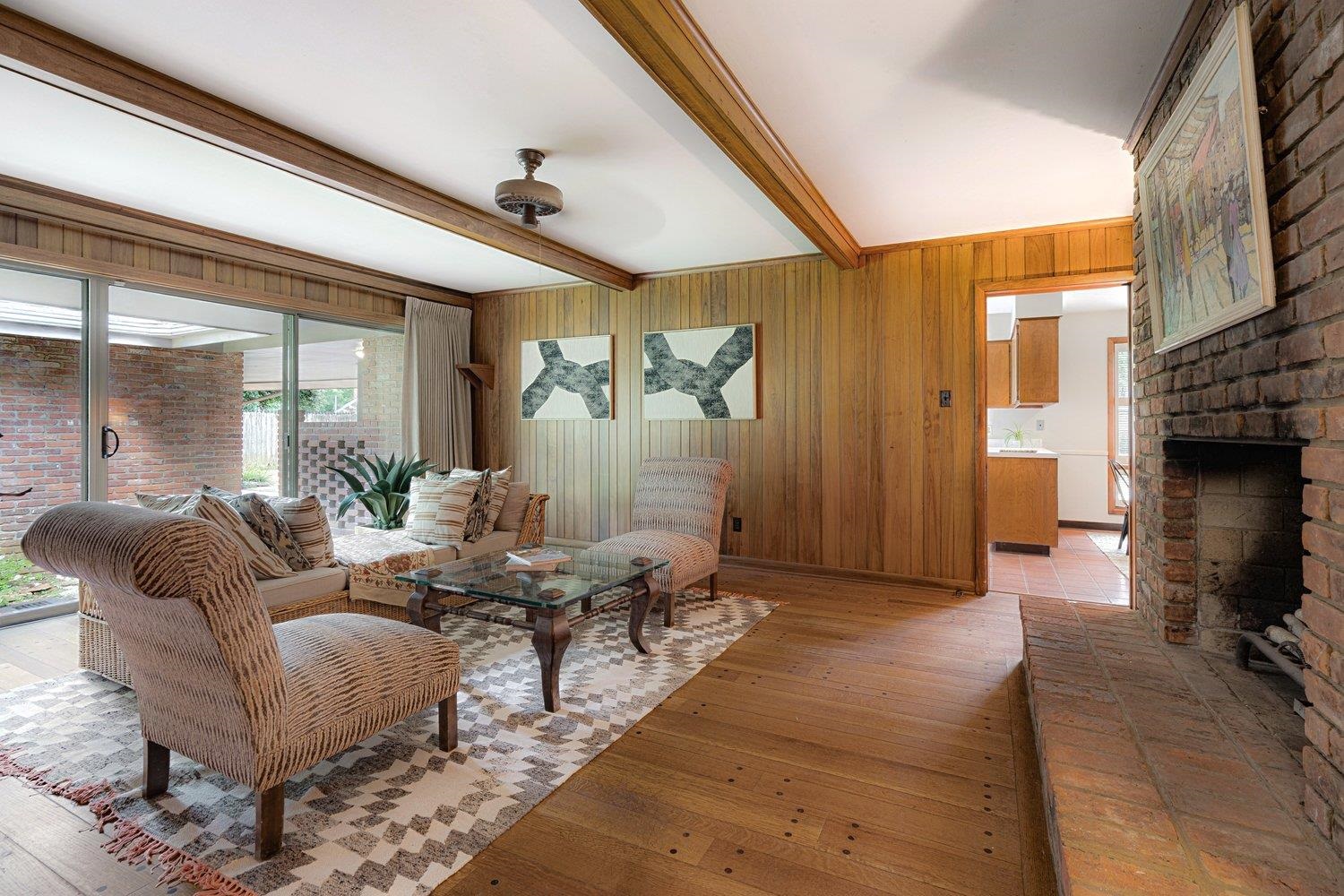 4317 Haverhill Road Memphis, TN 38111 - Photo 18 of 38 Living area with a fireplace, beamed ceiling, light wood-style flooring, and wooden walls