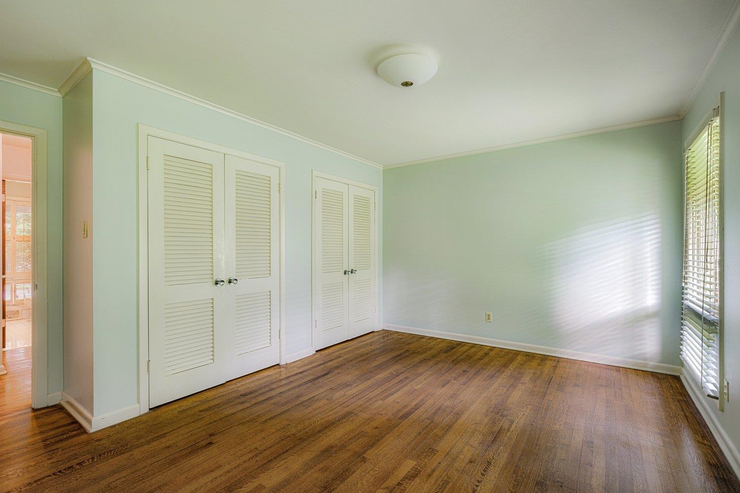4317 Haverhill Road Memphis, TN 38111 - Photo 26 of 38 Unfurnished bedroom featuring two closets, wood finished floors, and crown molding