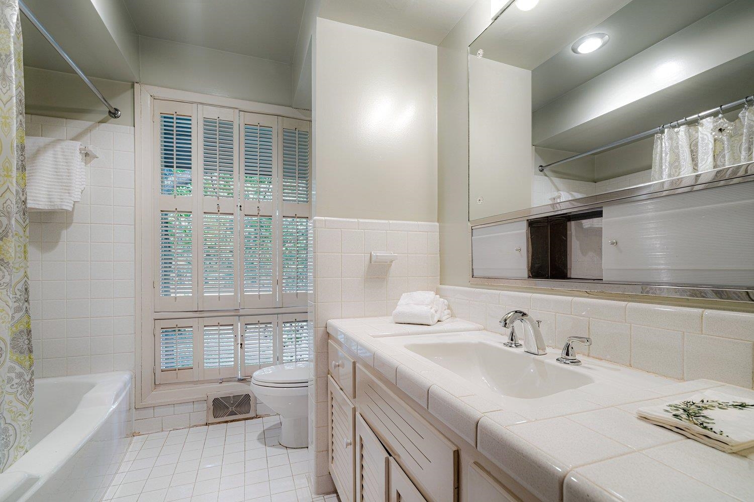 4317 Haverhill Road Memphis, TN 38111 - Photo 27 of 38 Bathroom with tile patterned flooring, tile walls, vanity, shower / tub combo, and a wainscoted wall