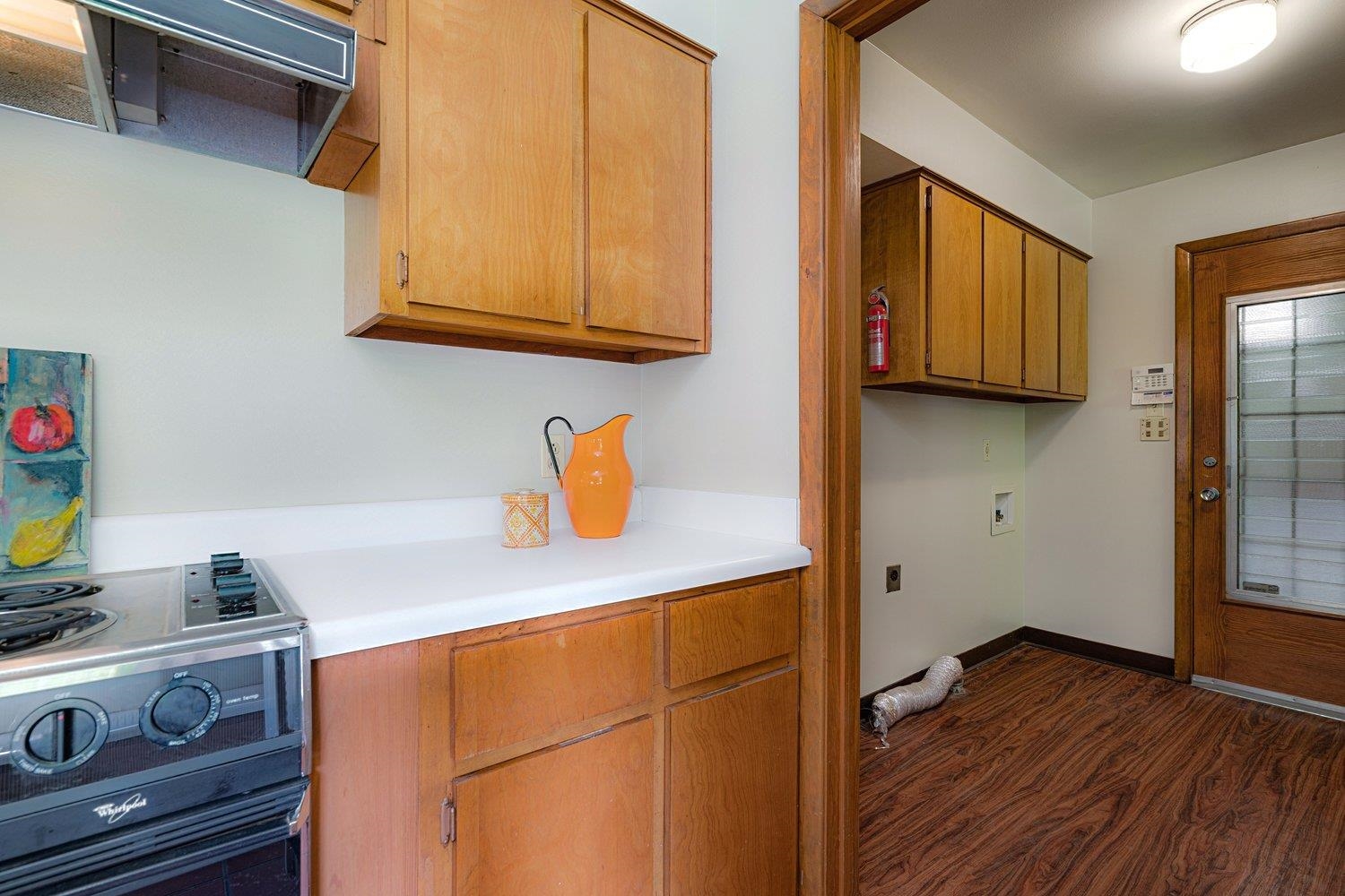 4317 Haverhill Road Memphis, TN 38111 - Photo 29 of 38 Kitchen with stainless steel range with electric cooktop, dark wood-style floors, extractor fan, light countertops, and brown cabinets