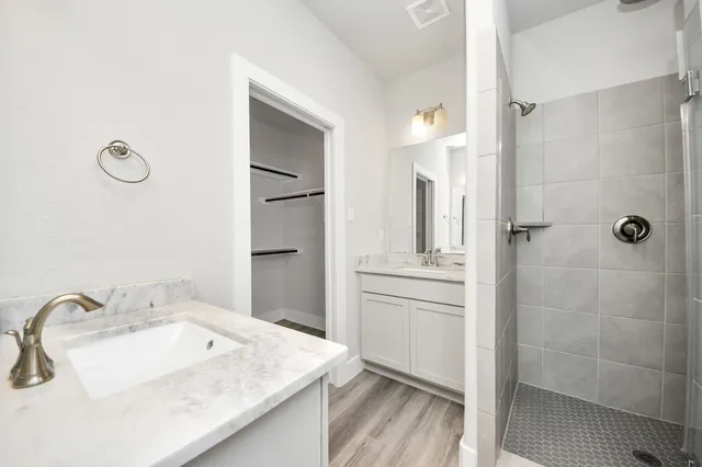 a bathroom with a sink shower and a mirror
