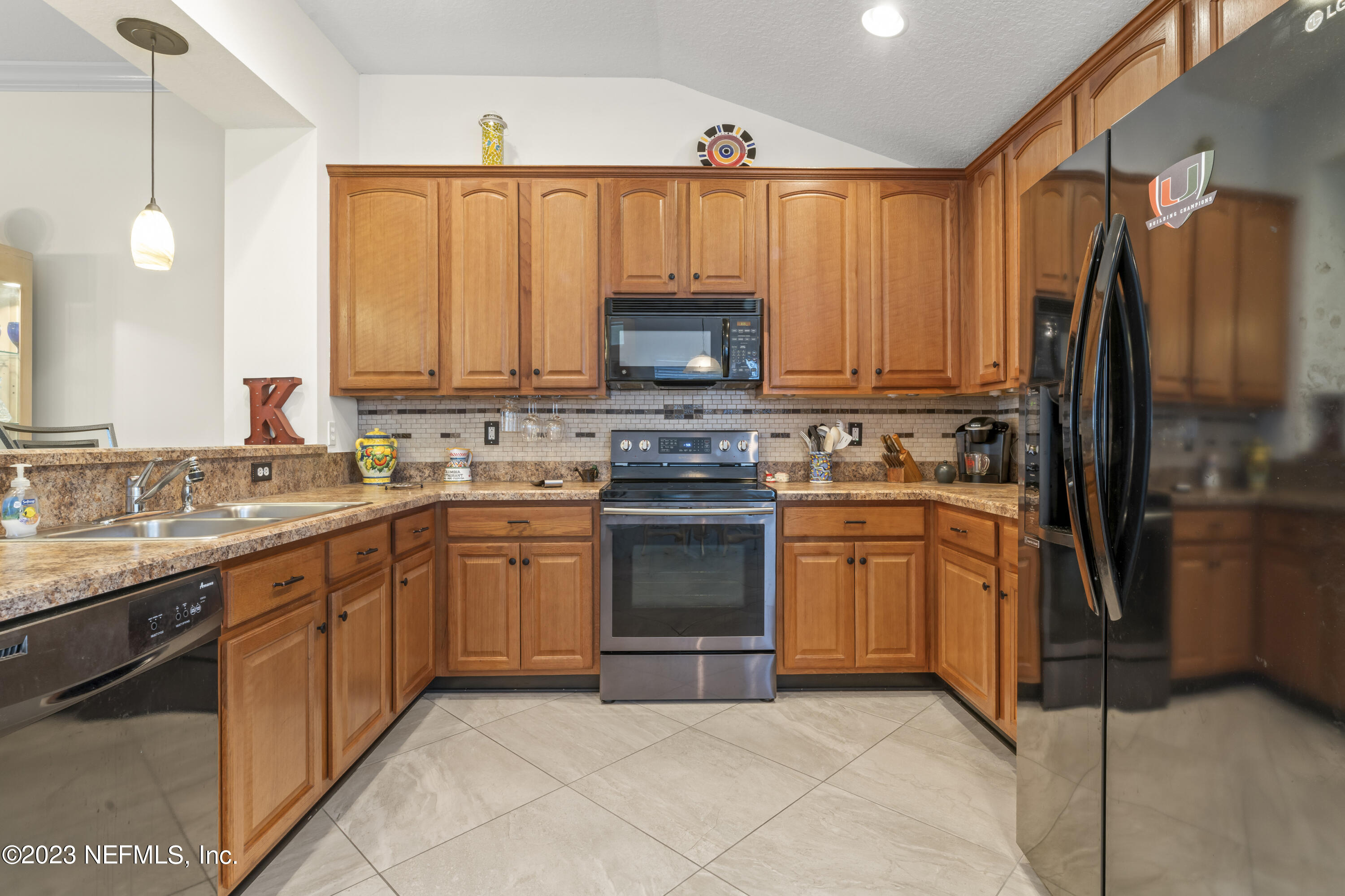 1840 Copper Stone Drive, Unit D Fleming Island, FL 32003 - Photo 13 of 66 a kitchen with stainless steel appliances granite countertop a stove top oven a sink and dishwasher