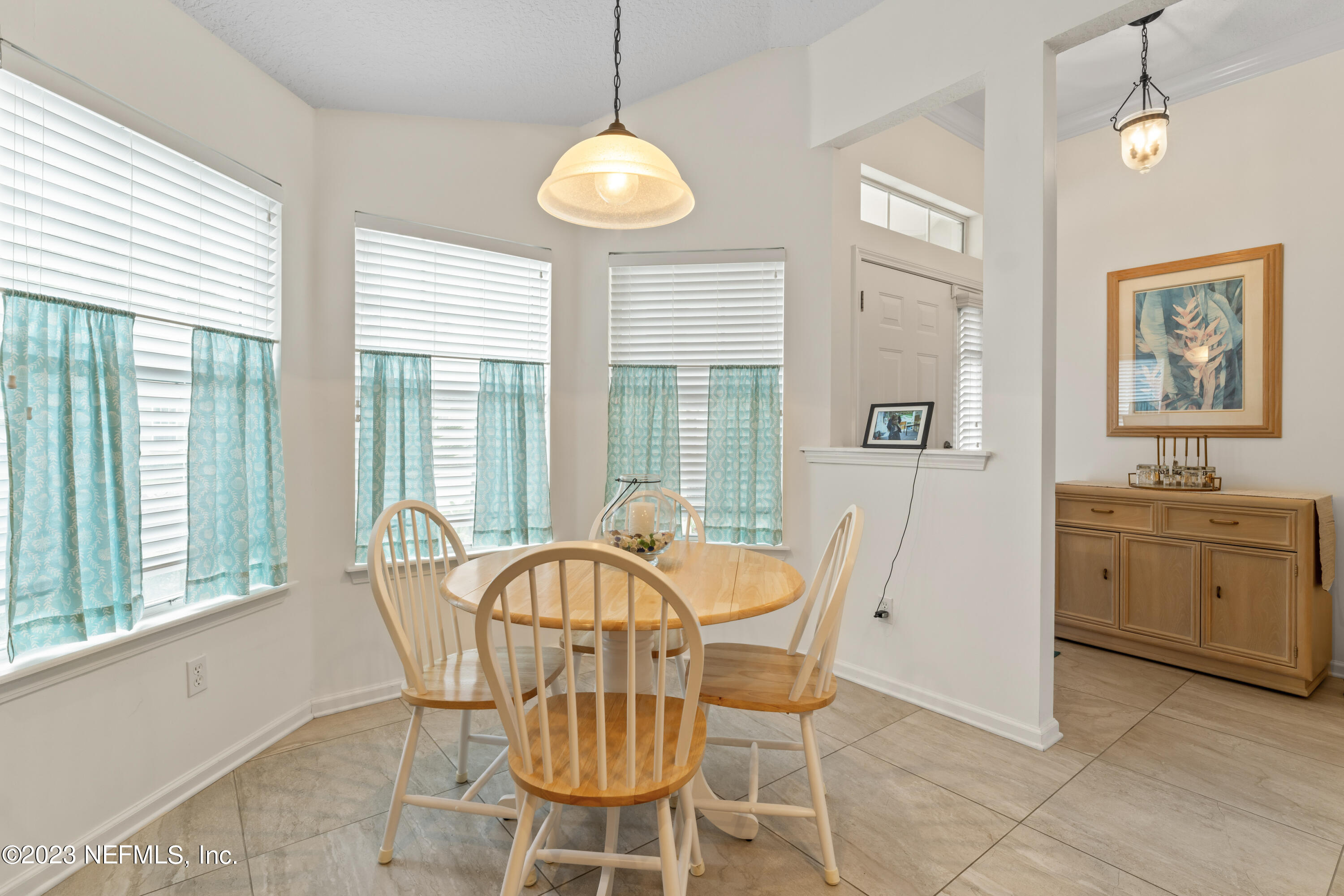 1840 Copper Stone Drive, Unit D Fleming Island, FL 32003 - Photo 14 of 66 a dining room with furniture a chandelier and window