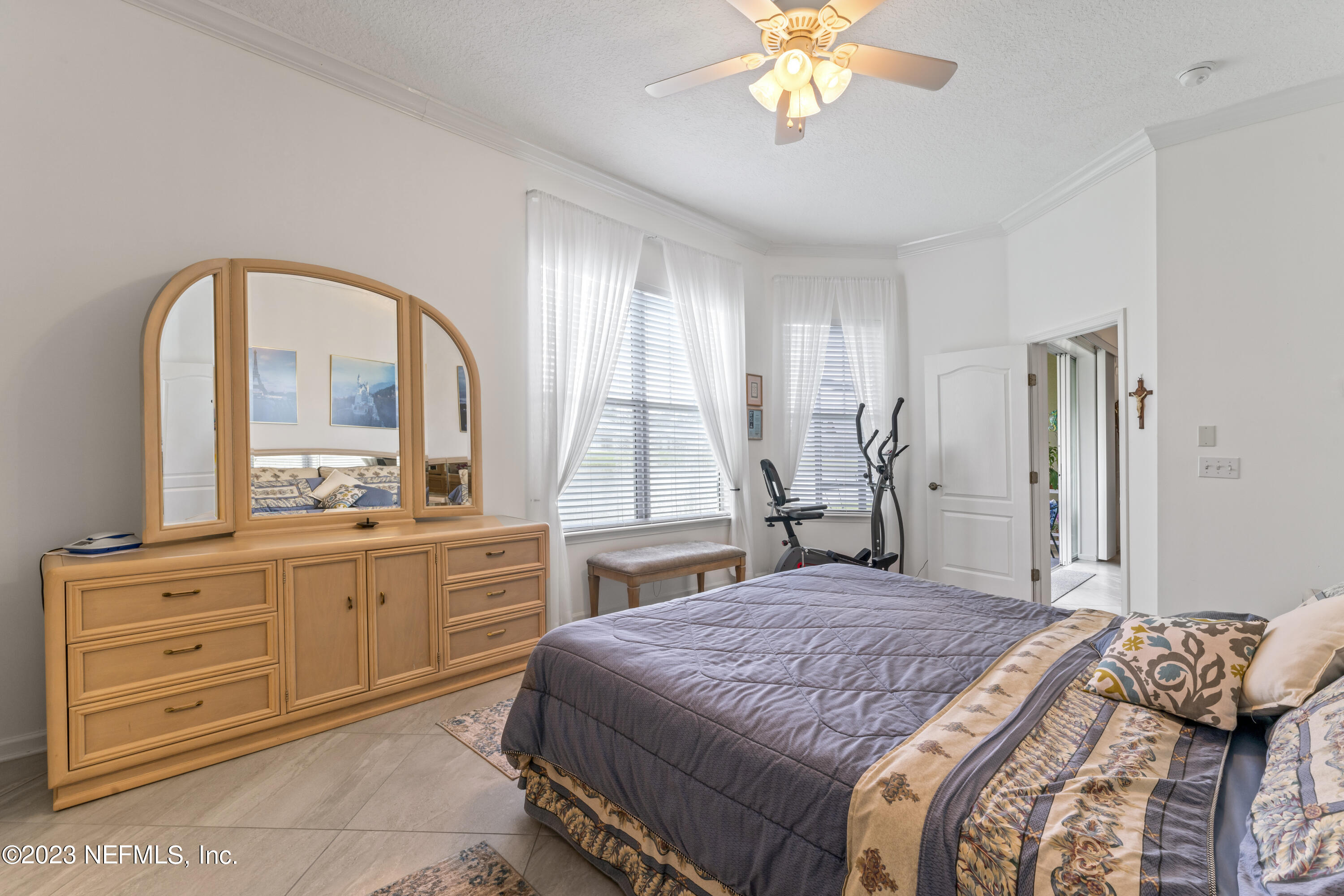 1840 Copper Stone Drive, Unit D Fleming Island, FL 32003 - Photo 17 of 66 a bedroom with a large bed and a chandelier