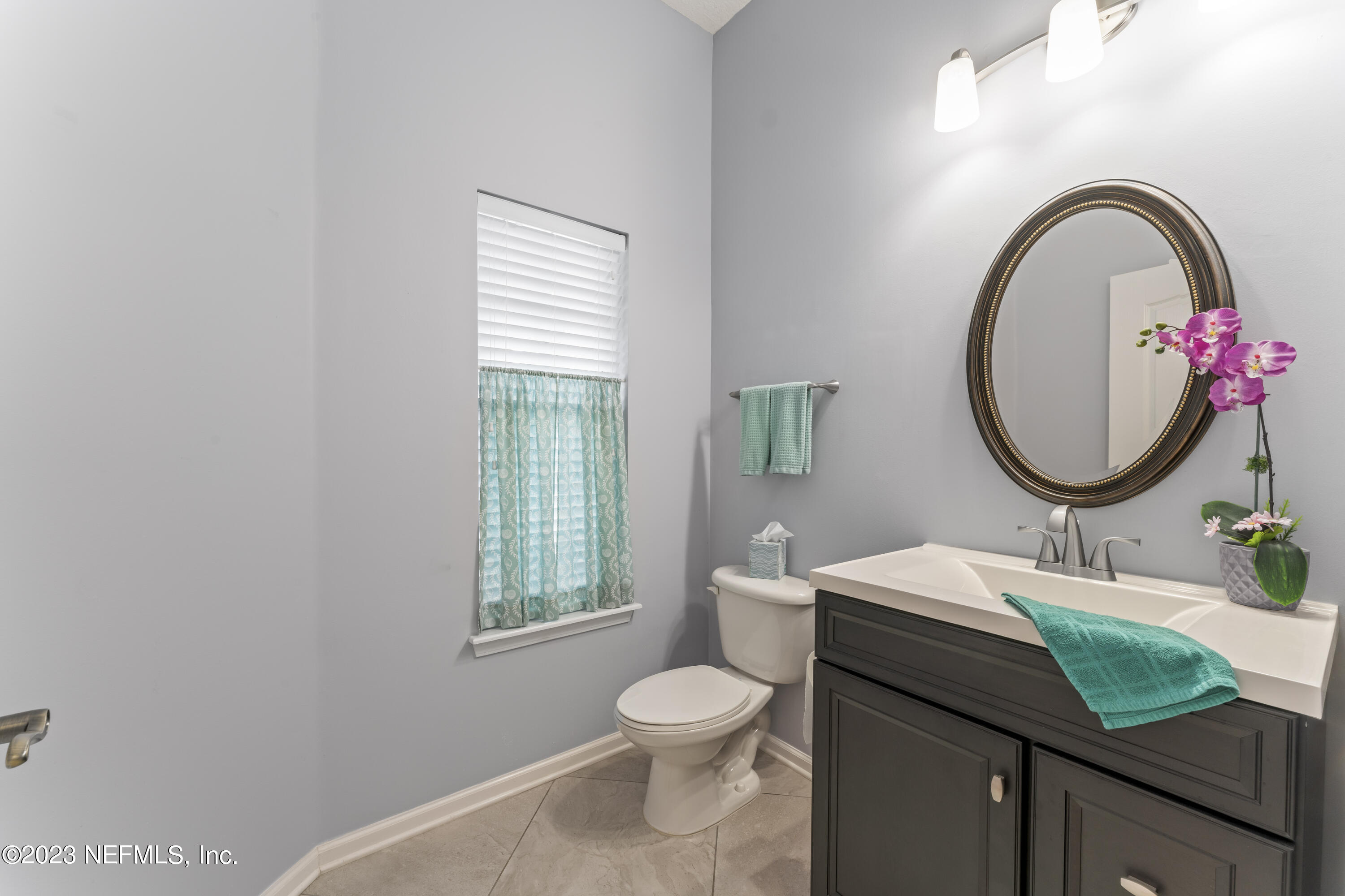 1840 Copper Stone Drive, Unit D Fleming Island, FL 32003 - Photo 22 of 66 a bathroom with a granite countertop toilet a sink and a mirror